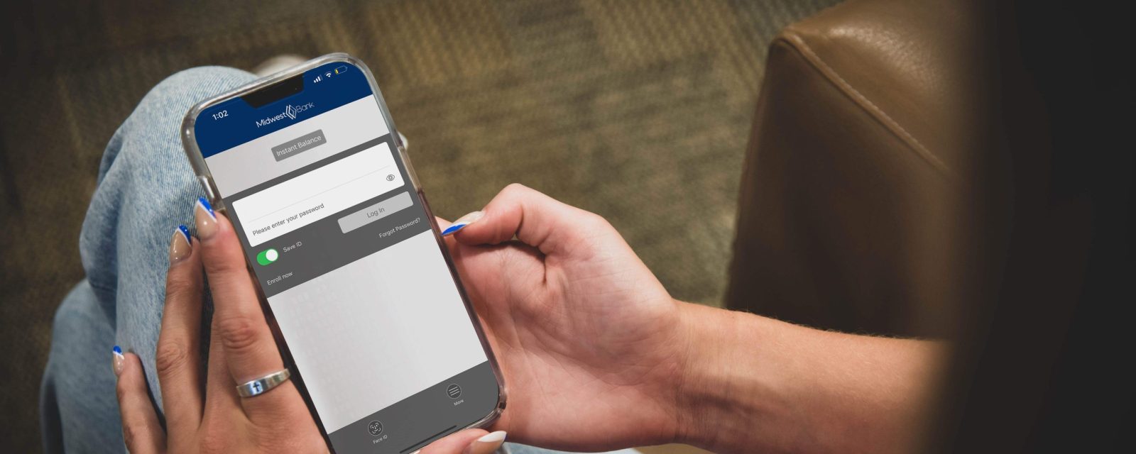 Someone holding a phone with the Midwest Bank mobile app open on the phone