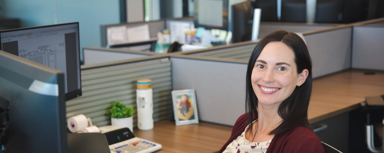 Paige smiling at her desk.