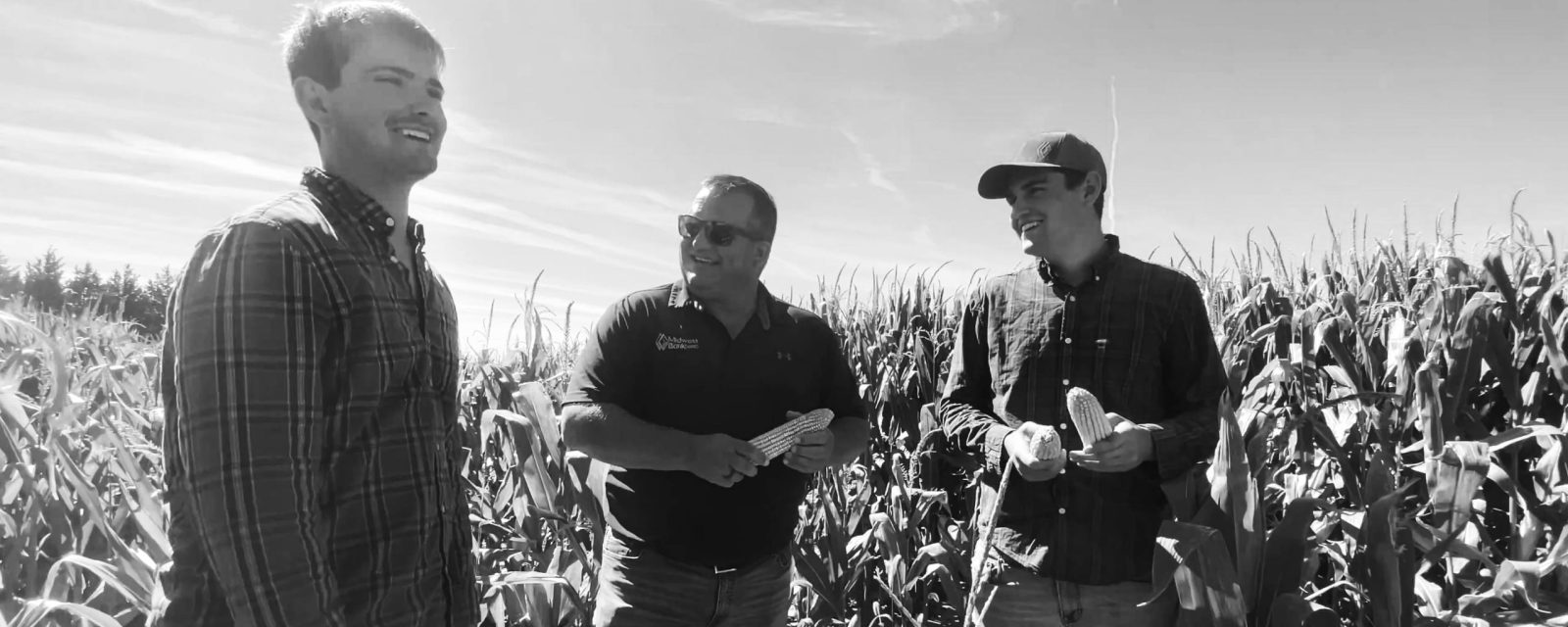 Josh Gossman, Crop Insurance Agent out of Pierce, talking in the field with some farmers.