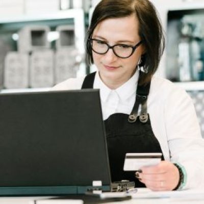 Restaurant owner using her debit card to purchase on her computer