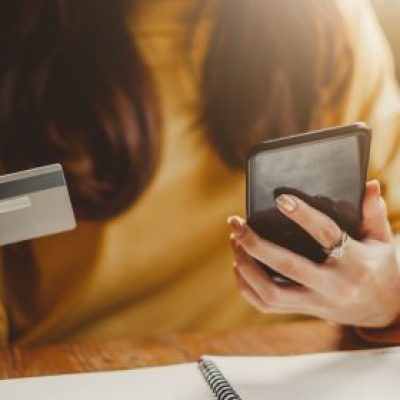 Woman holding her phone and her credit card