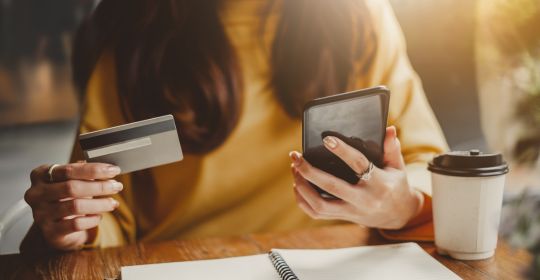 Woman holding her phone and her credit card