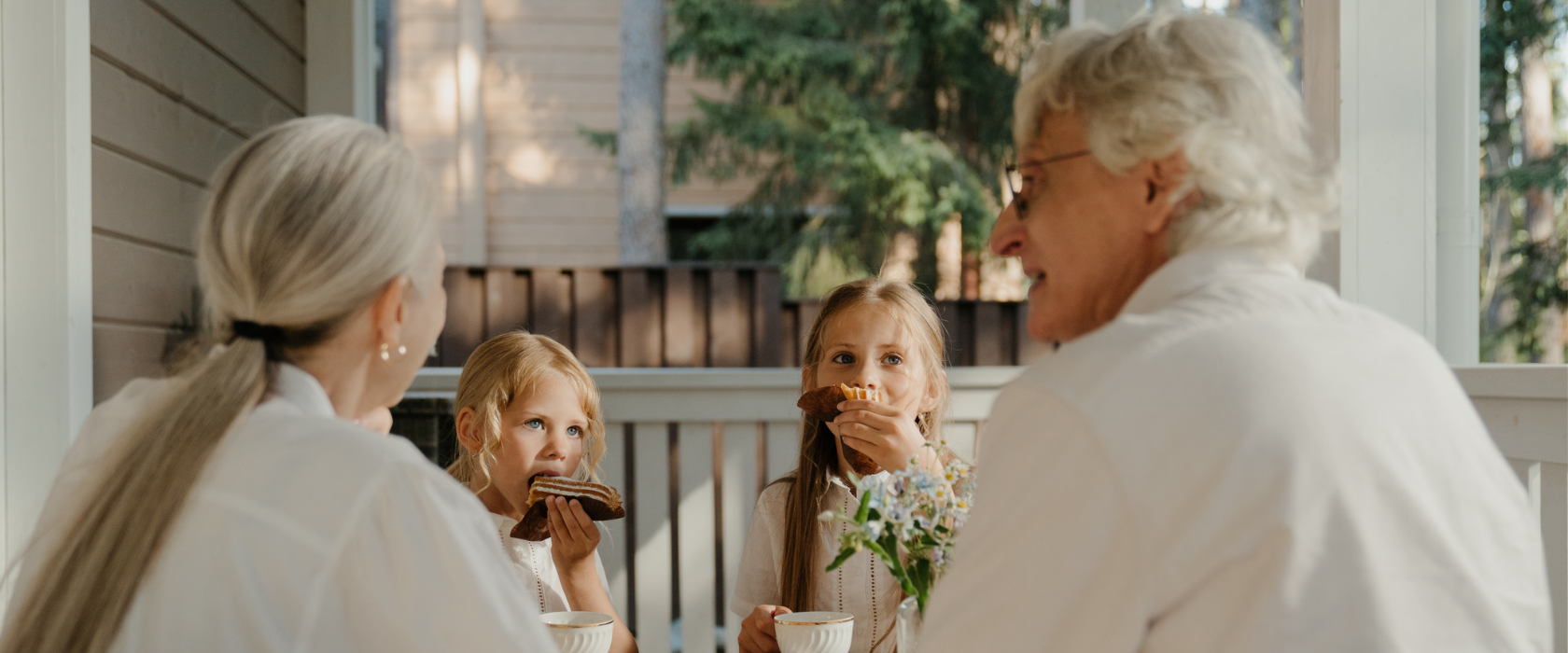 happy older couple having a snack on their porch with their grandkids