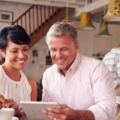 Older couple looking at iPad at kitchen table