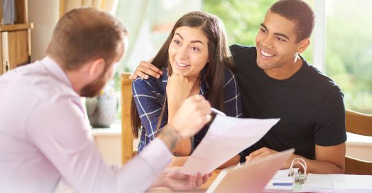 Couple meeting with their mortgage lender to review paperwork