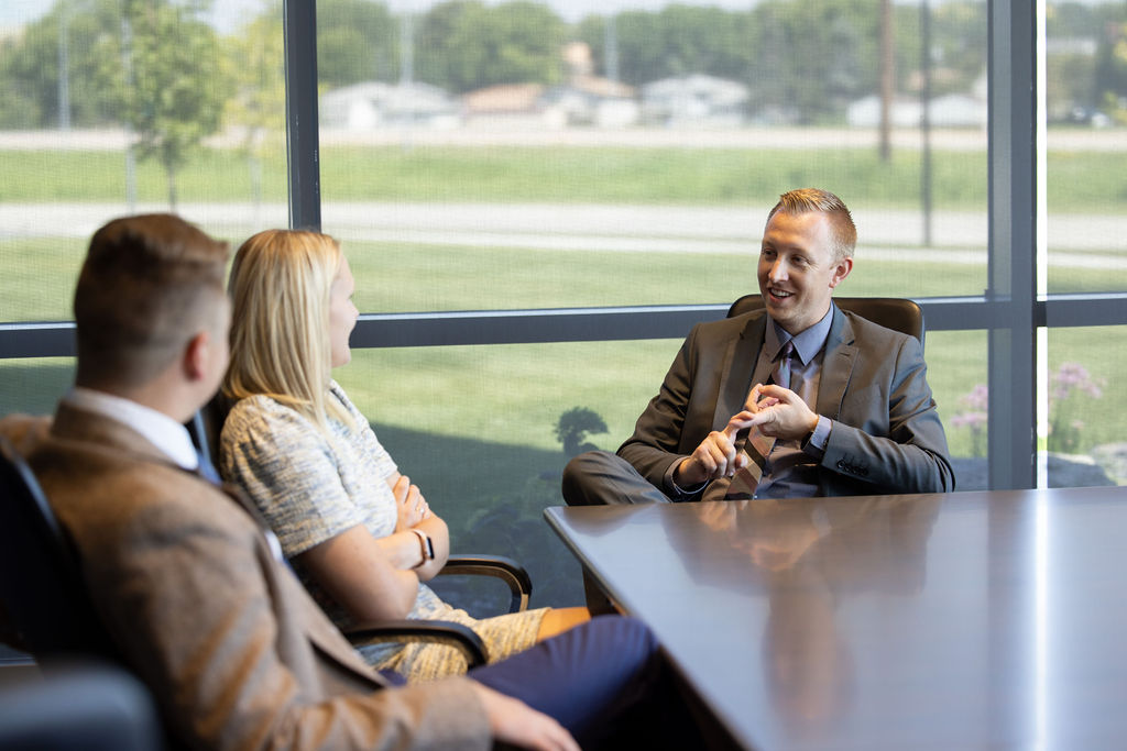 Steven, Ashton, and Lane talking in the conference room