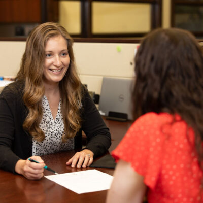 Julie with a client at her desk