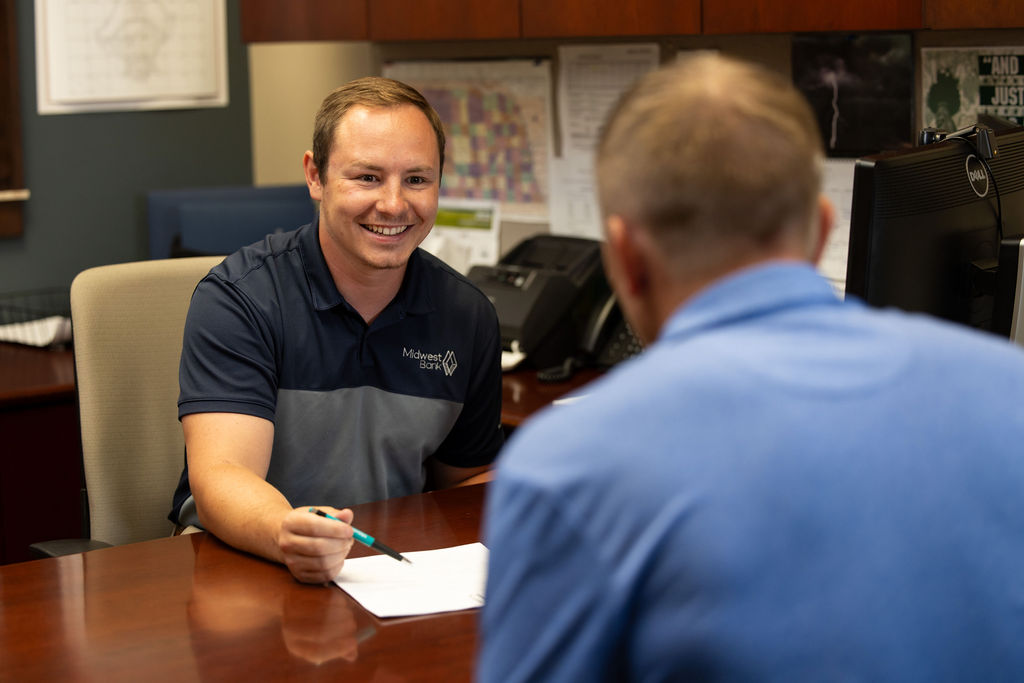 Corby, a bank lender, helping a client in his office