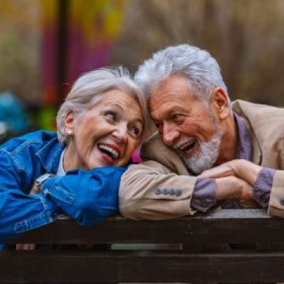 Older happy couple on a park bench