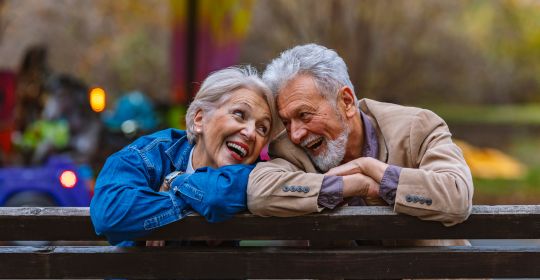 Older happy couple on a park bench