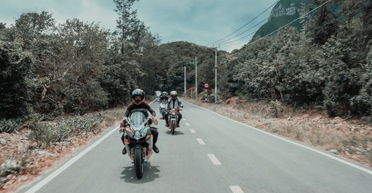 a group of motorcycles driving down the highway on a cloudy day