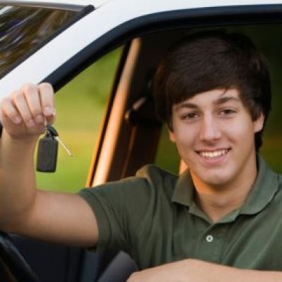 Highschool boy holding the keys to his first car