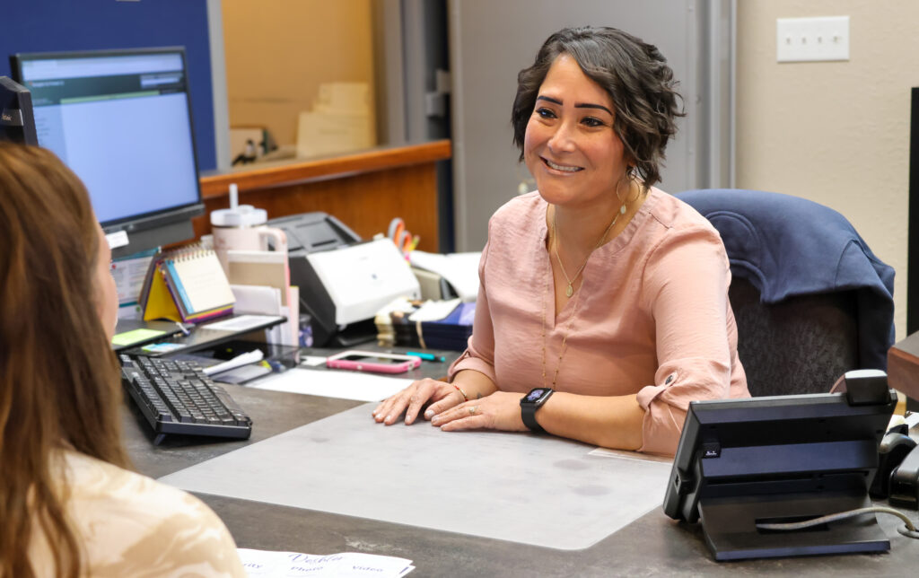 Dora in Deshler working with a client at her desk