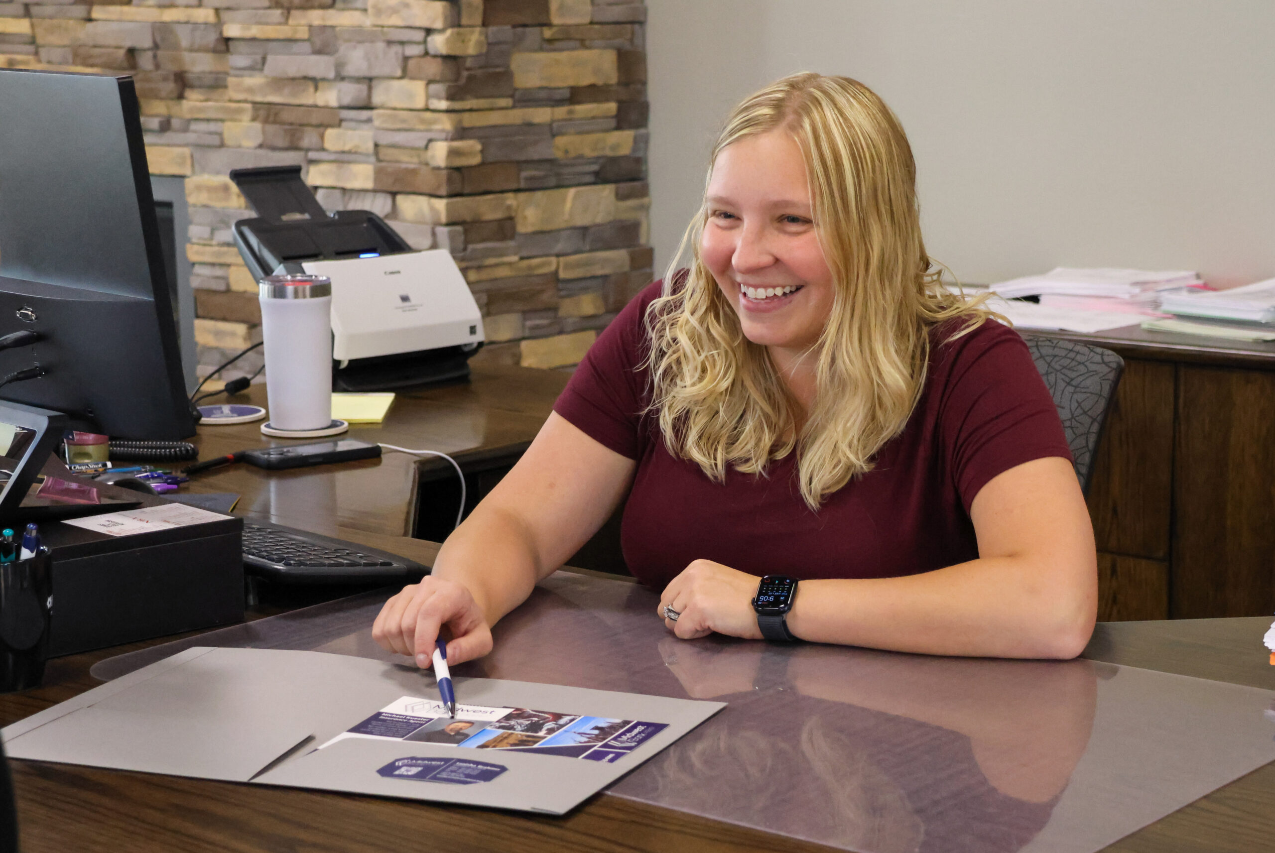 Tanisha Brahmer at the Pilger branch sitting at her desk helping a client.