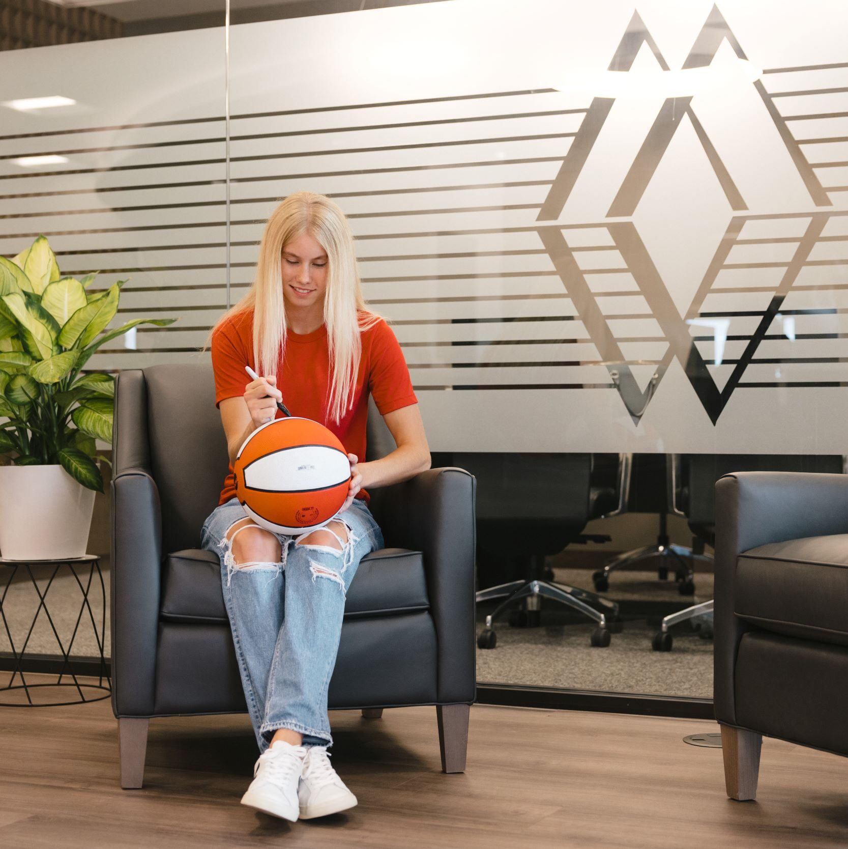 Britt Prince autographing a basketball in the Lincoln branch.