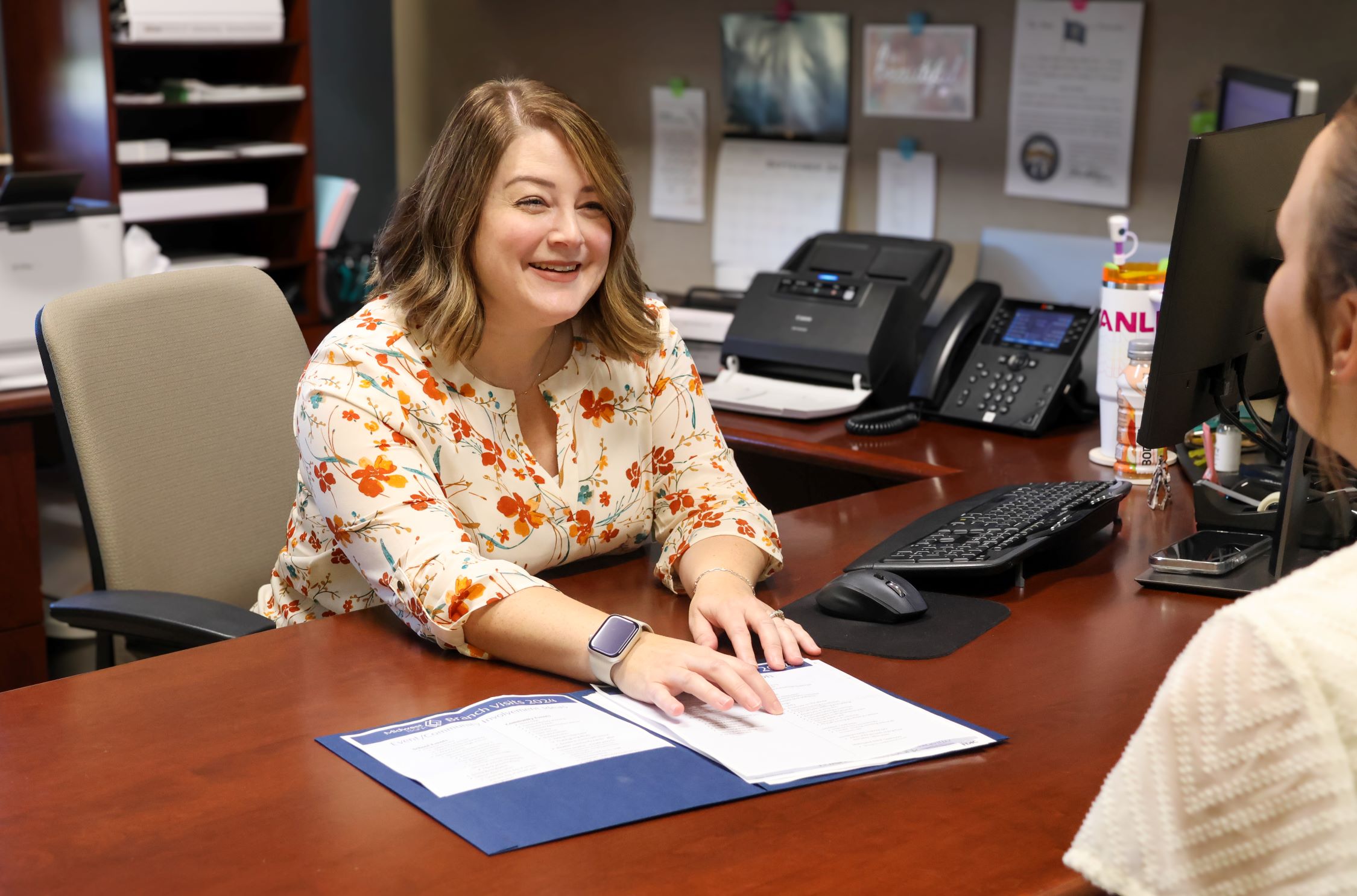 Jody, Retail Banking Manager at Plainview working with a client at her desk